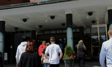 Nuoria kävelemässä Aalto-yliopiston ovista sisään.